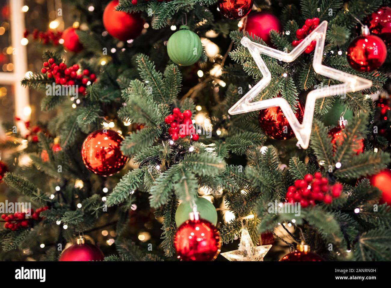 Christmas pine tree branch with decorations red balls gifts and star Stock Photo