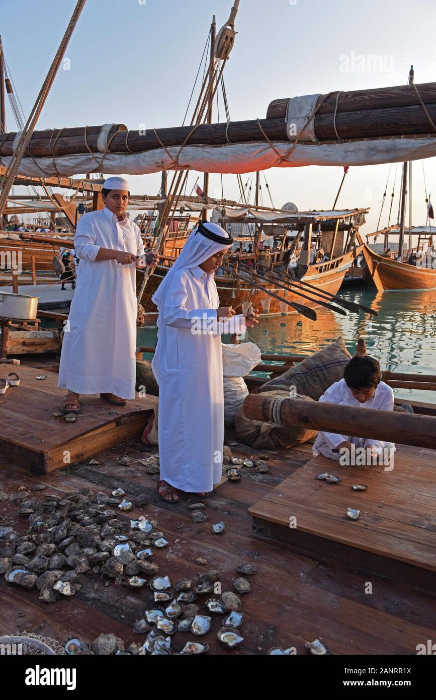 Qatari boys opening oysters on the dhow, Katara Traditional Dhow