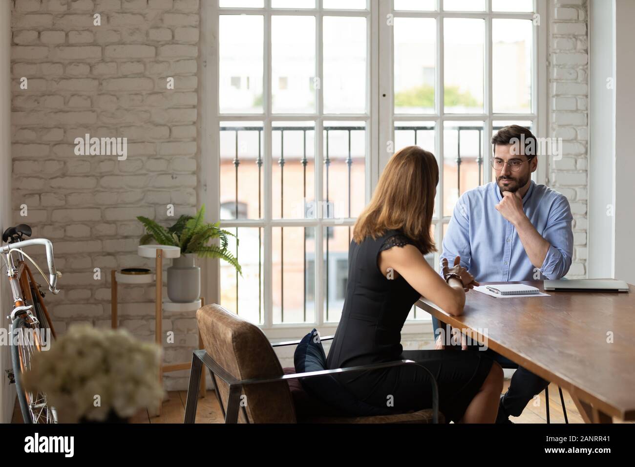 Doubtful hr manager listening to job applicant at interview Stock Photo