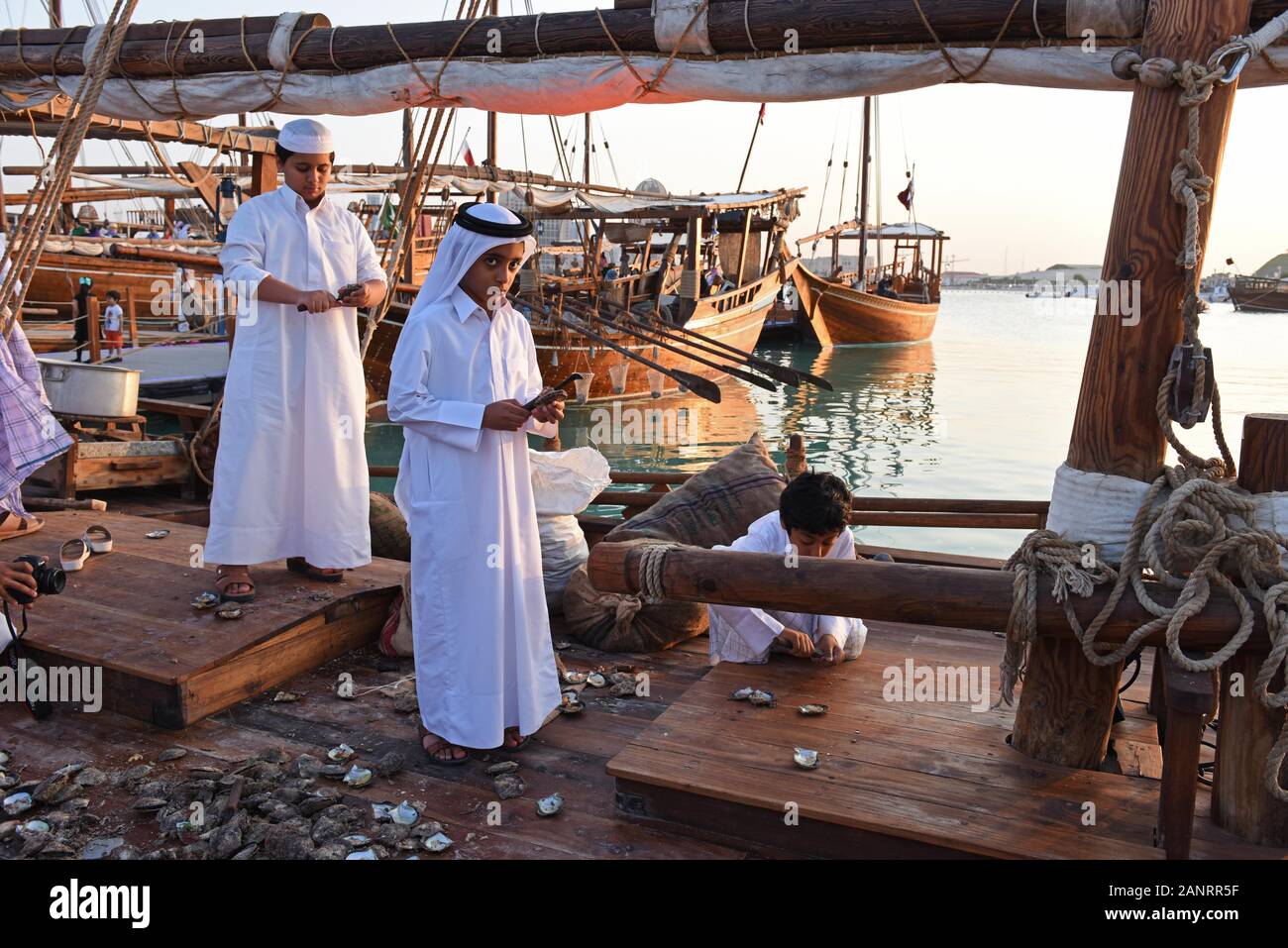 Qatari boys opening oysters on the dhow, Katara Traditional Dhow