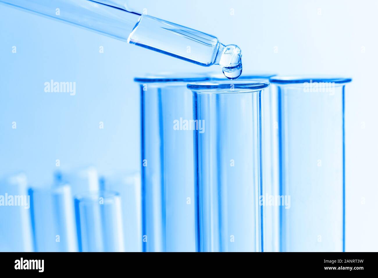 Chemical pipette dropper and test tube on blue background science Stock