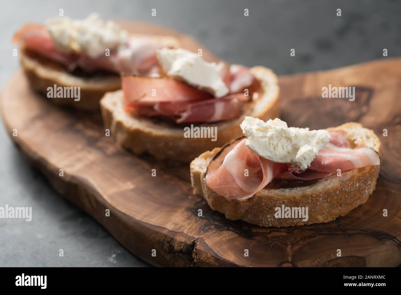 Bruschetta with panchetta, ricotta and fig jam, shallow focus Stock