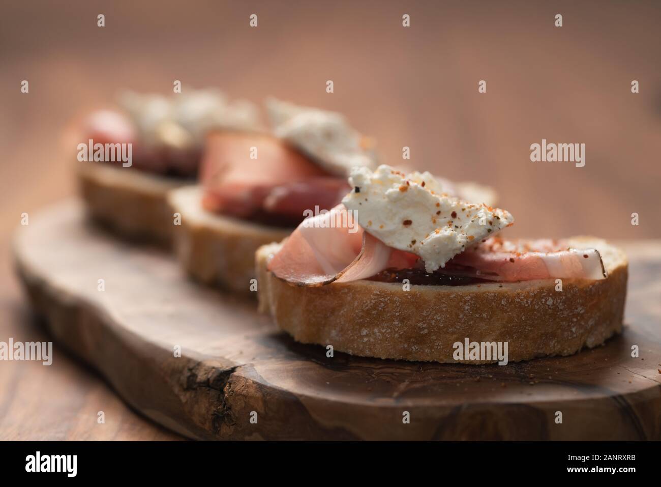 Bruschetta with panchetta, ricotta and fig jam, shallow focus Stock