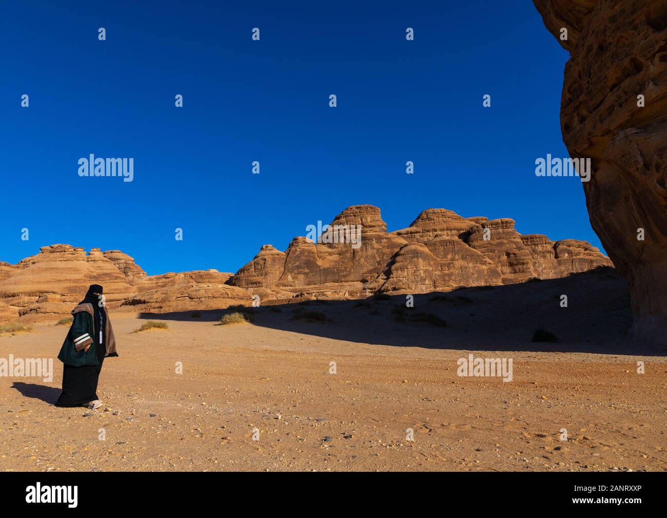 Saudi woman in the rocky landscape of Madain Saleh, Al Madinah Province, Alula, Saudi Arabia Stock Photo