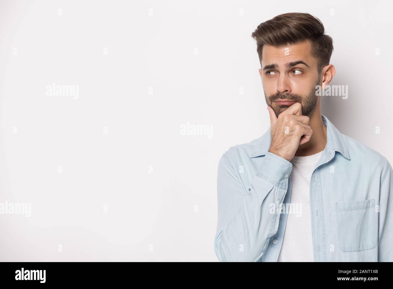 Pensive young guy looking aside at empty copy space. Stock Photo