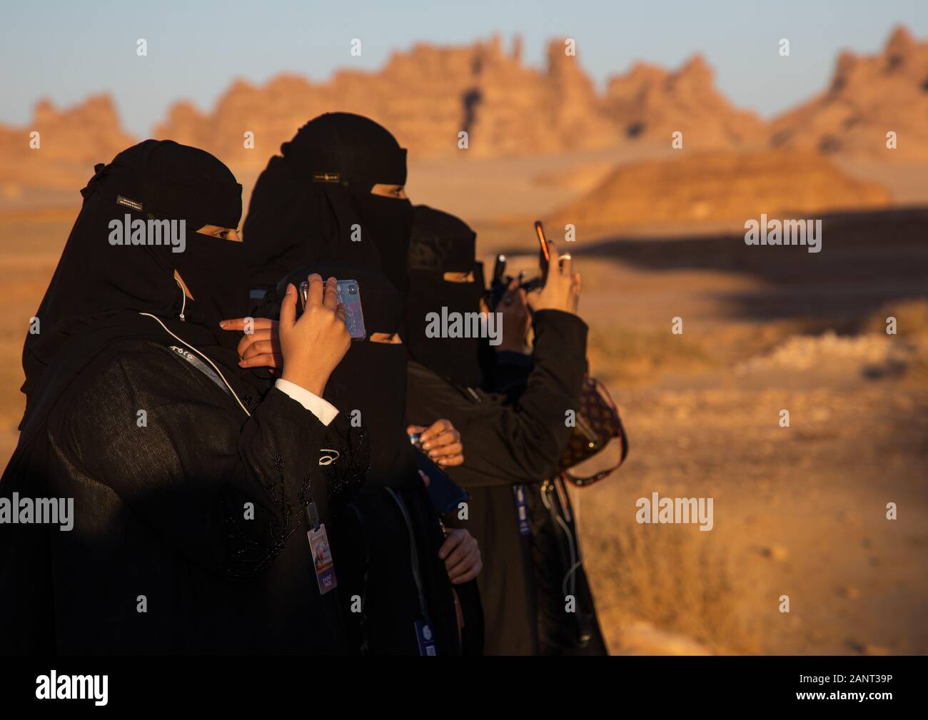 Saudi women in black niqabs taking pictures, Al Madinah Province, Alula, Saudi Arabia Stock Photo