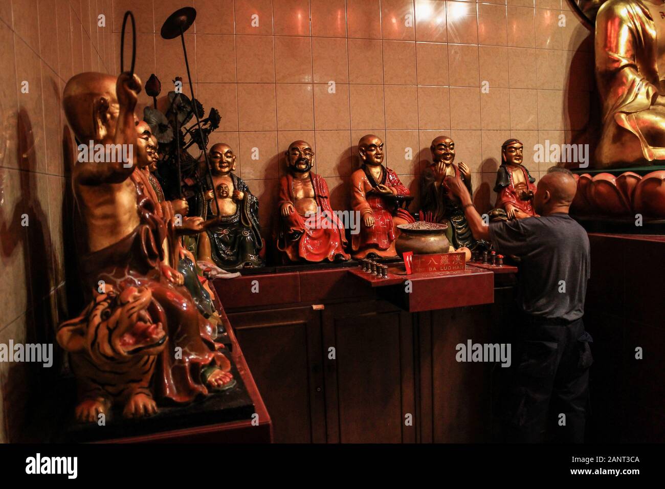 A man clean a statue during the celebration at Dharma Ramsi temple in