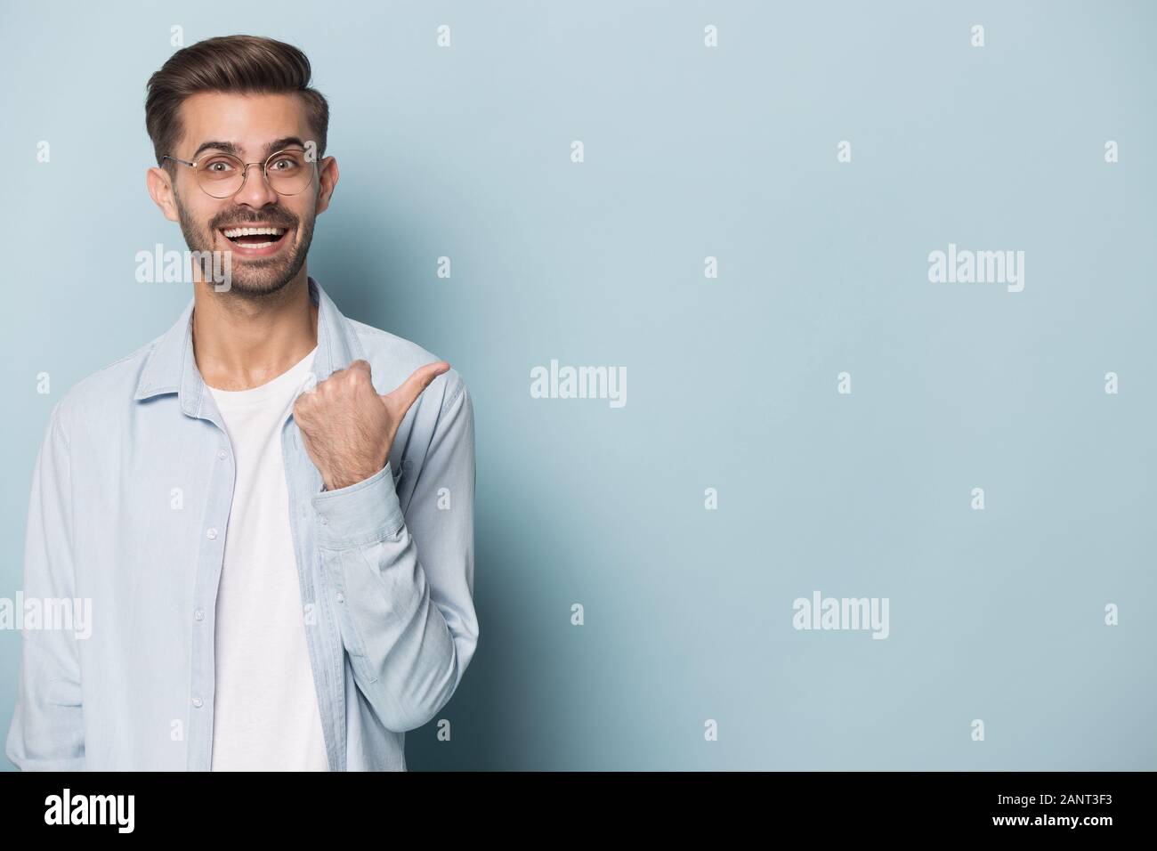 Happy surprised young man showing empty copy space. Stock Photo