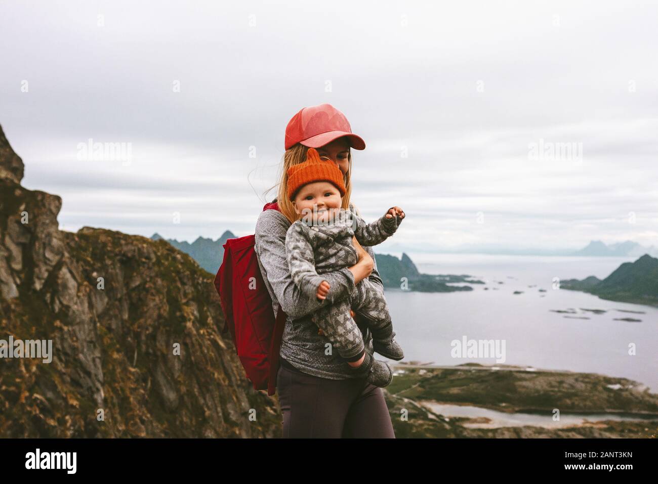 Mother and cute baby hiking together family travel vacations healthy lifestyle woman and child active leisure outdoor in Norway mountain trail Stock Photo