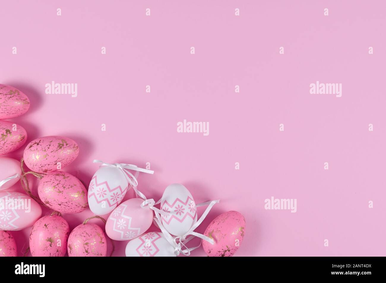 Easter flat lay with easter eggs in corner and empty copy space on pink ...