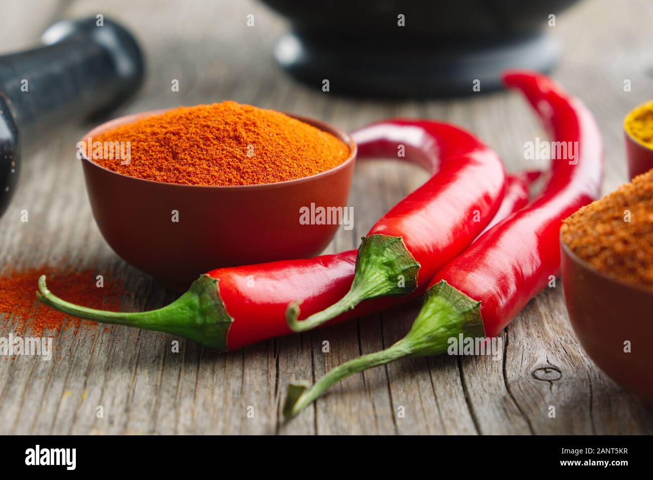 Whole and ground to powder red chili pepper. Mortar and pestle Stock