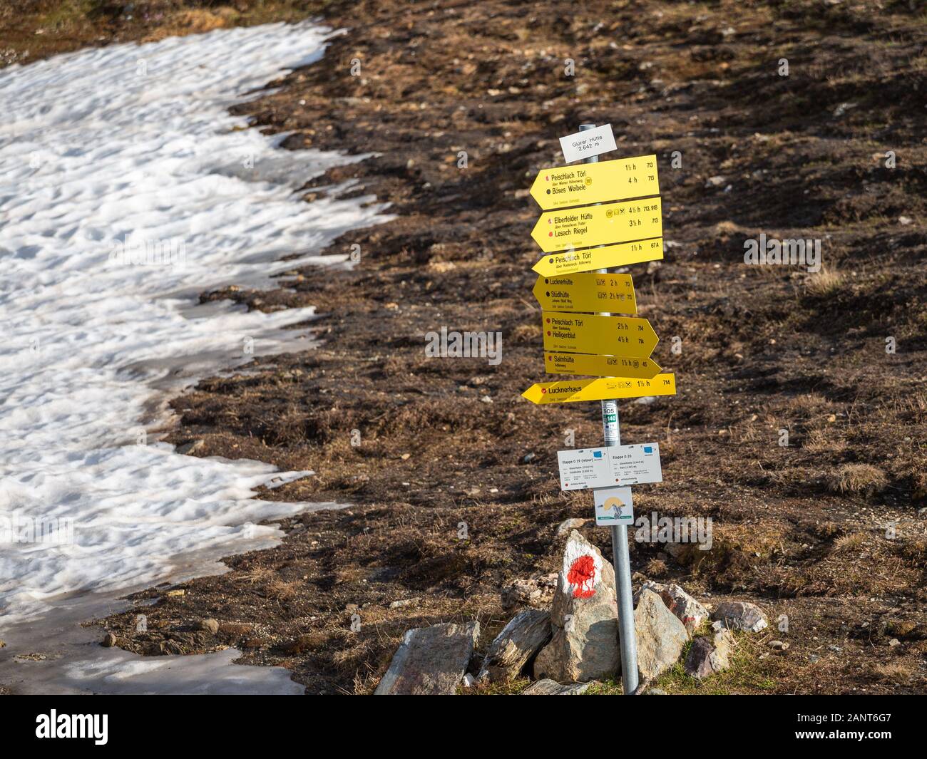 Yellow hiking signs, signposts, informations for trekking near Glorer Hütte refuge.  Austrian Alps. Europe. Stock Photo