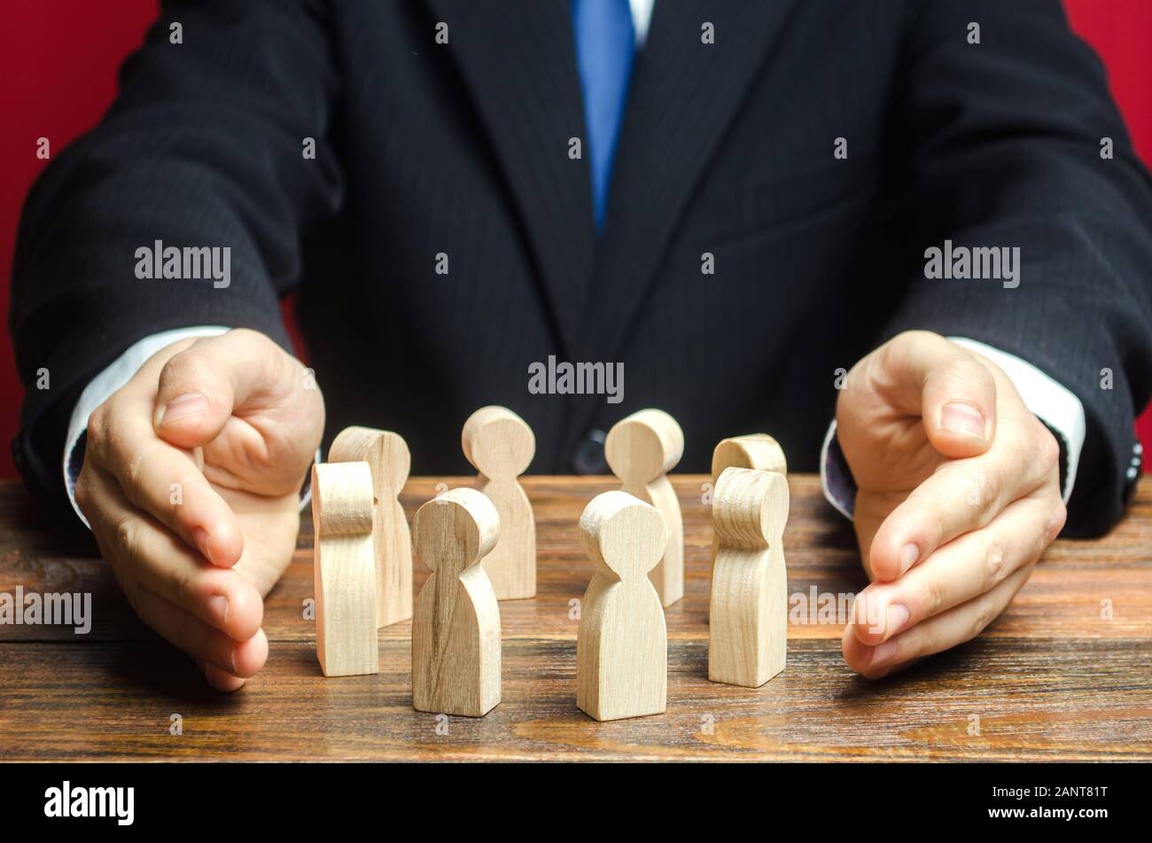 Businessman defending his team with a gesture of protection. Care for employees. Life insurance. Security and safety in a business team. Human resourc Stock Photo