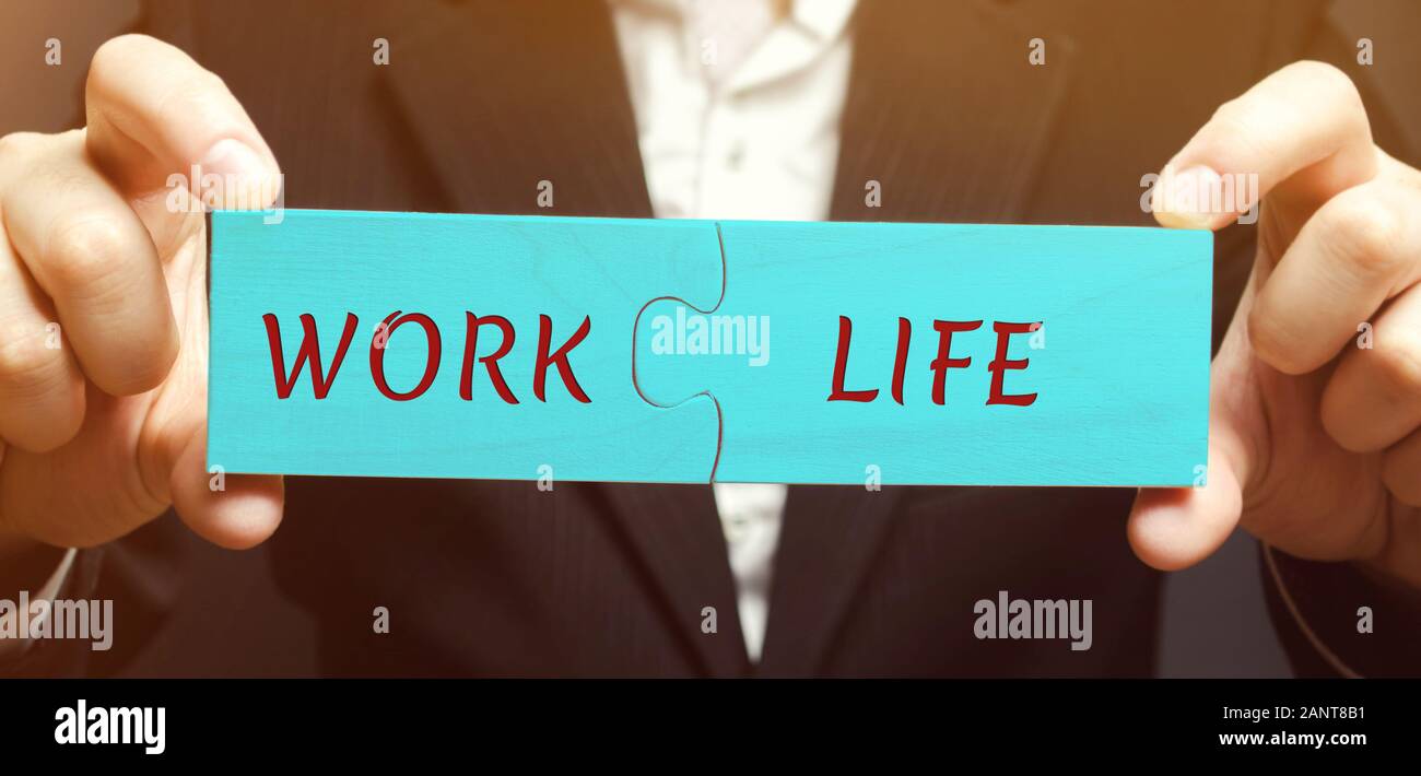 A man collects wooden puzzles with the words Work and Life. The concept ...