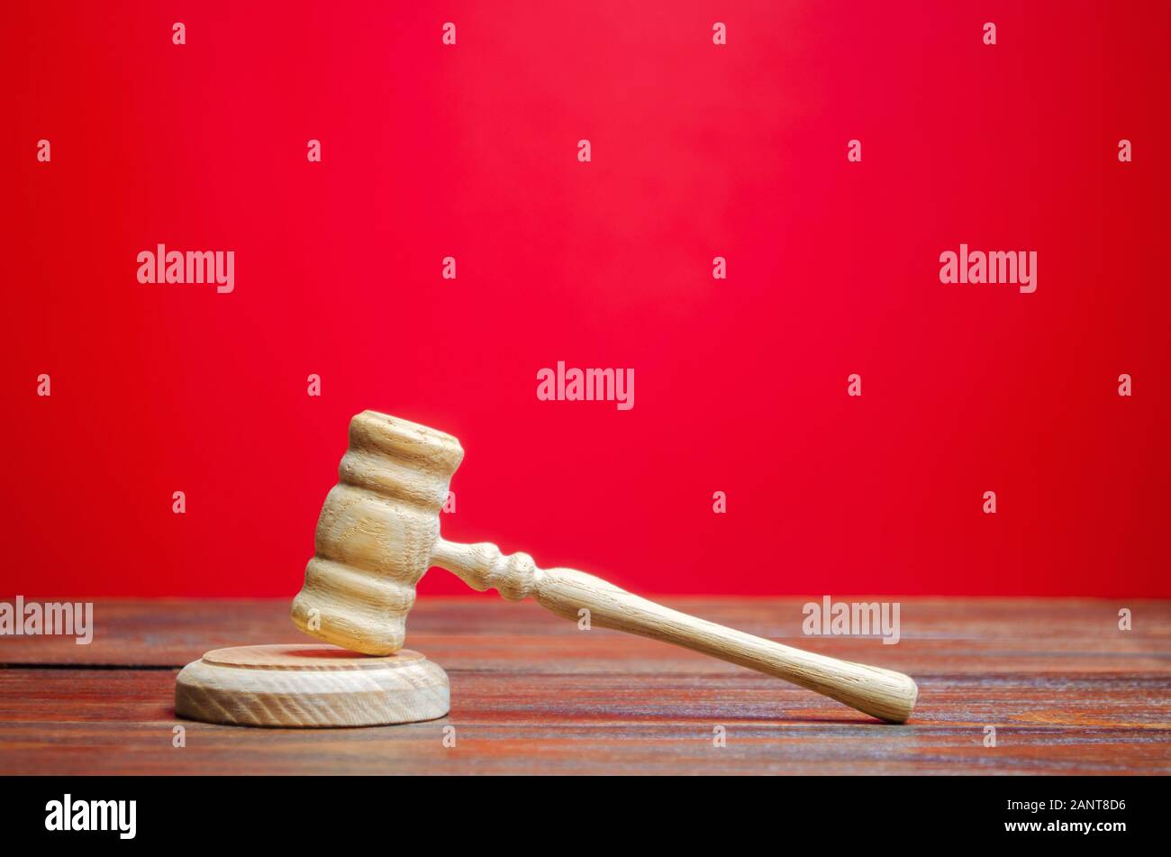 Judge's hammer on a red background. The judicial system. Norms, rules and laws. Conflict resolution in court. Court case, settling disputes. Protectio Stock Photo