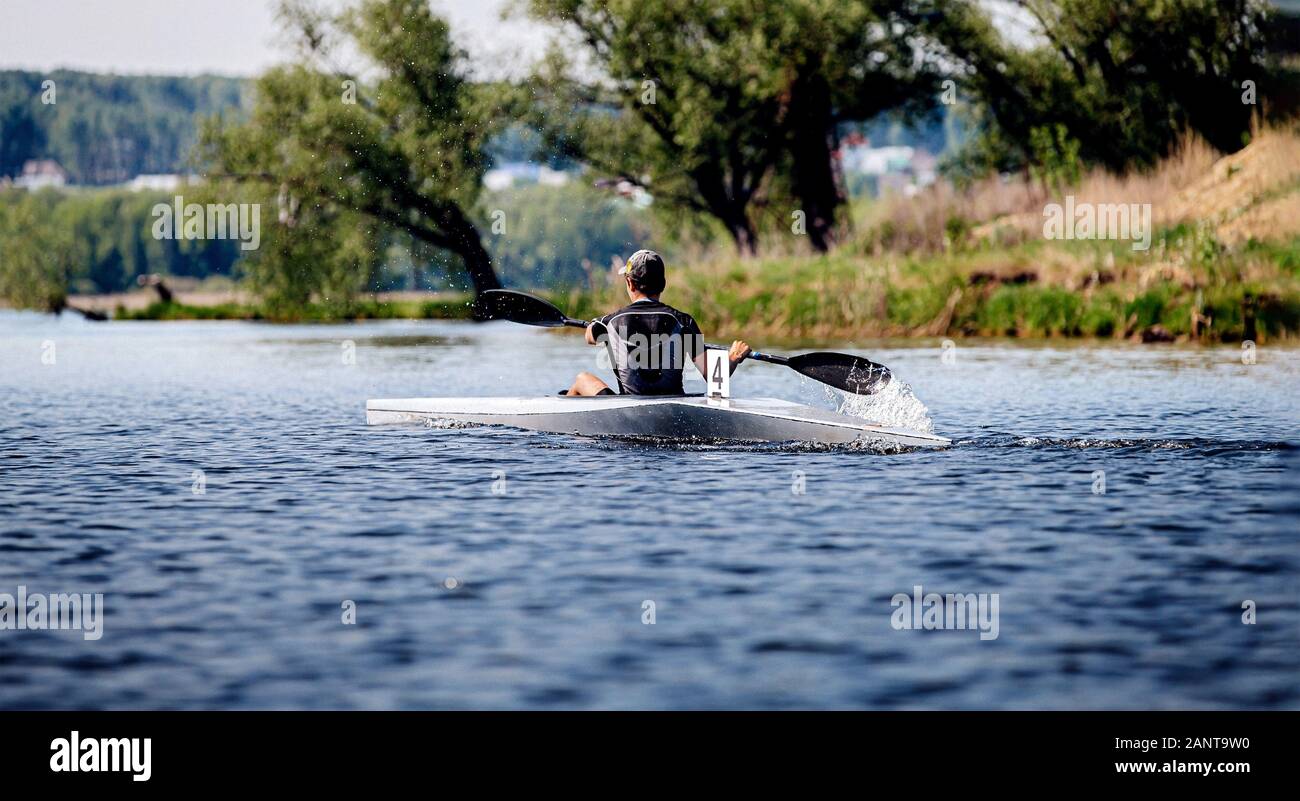 back athlete kayaker rowing in lake. kayak competition race Stock Photo