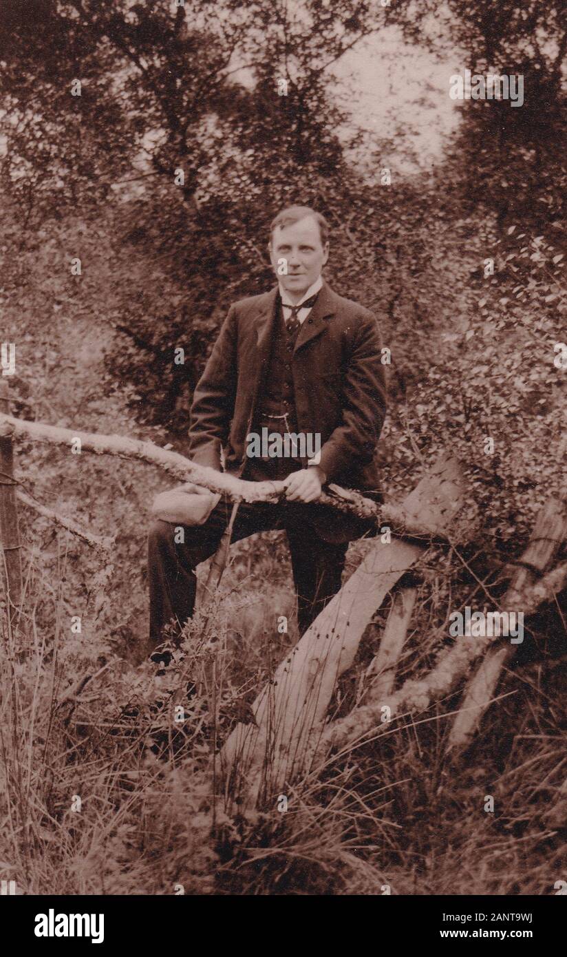 Vintage black and white 1920s photo of well dressed man wearing suit in a garden. Stock Photo