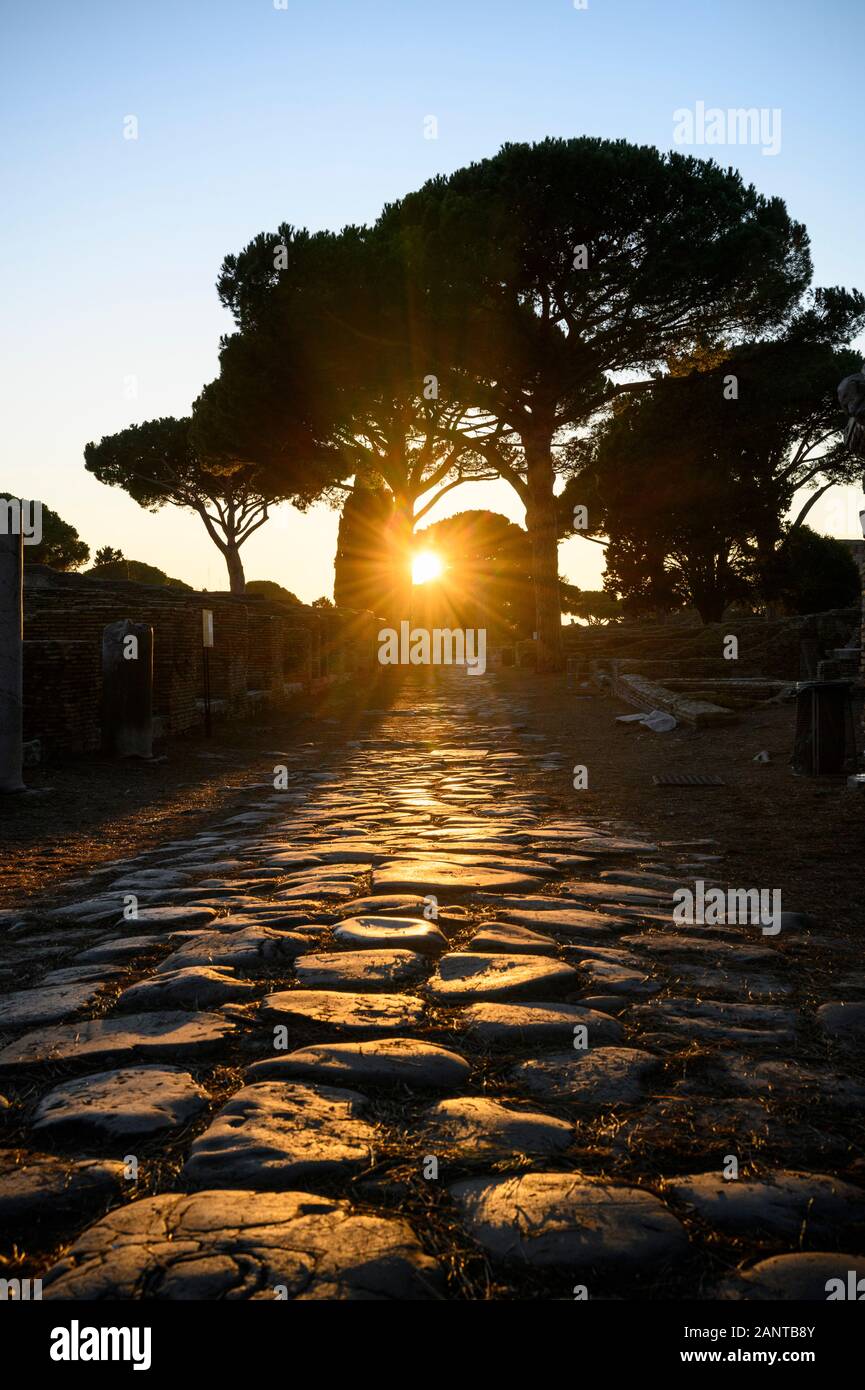 Rome. Italy. Ostia Antica. Sunset on the Decumanus Maximus, the principle Roman road in the east half of Ostia. It runs from east to west, starting at Stock Photo