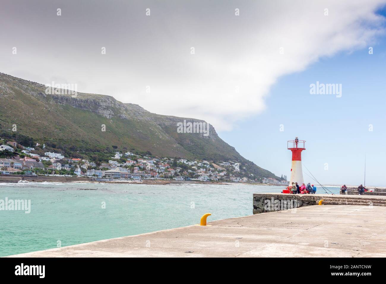 KALK BAY, WESTERN CAPE PROVINCE, SOUTH AFRICA - DECEMBER 30 2019: Recreational pier with beacon built in 1919 and fishermen at Kalk Bay harbour near C Stock Photo