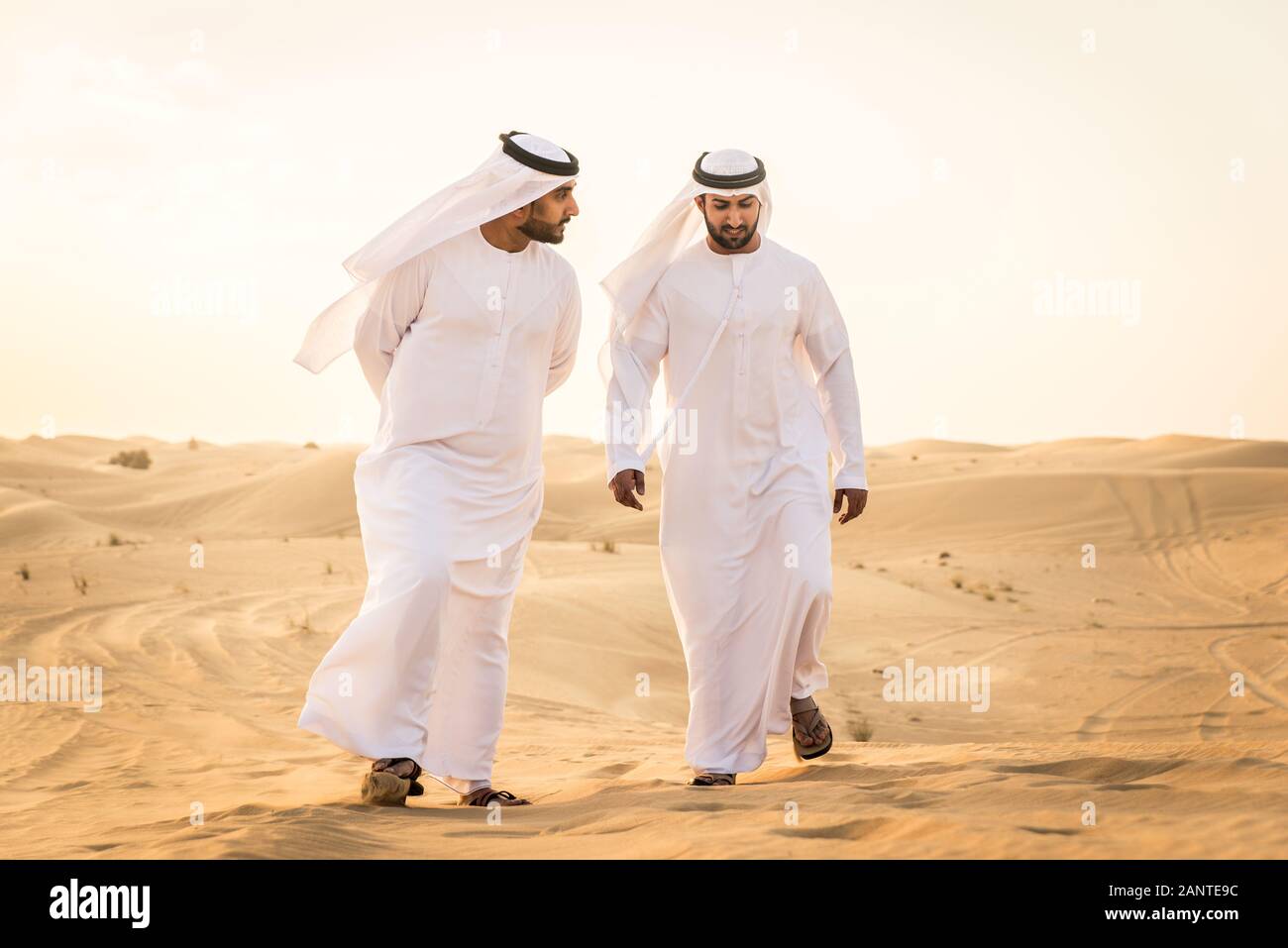 Arabian Men Witk Kandora Walking In The Desert Portrait Of Two Middle Eastern Adults With Traditional Arabic Dress Stock Photo Alamy