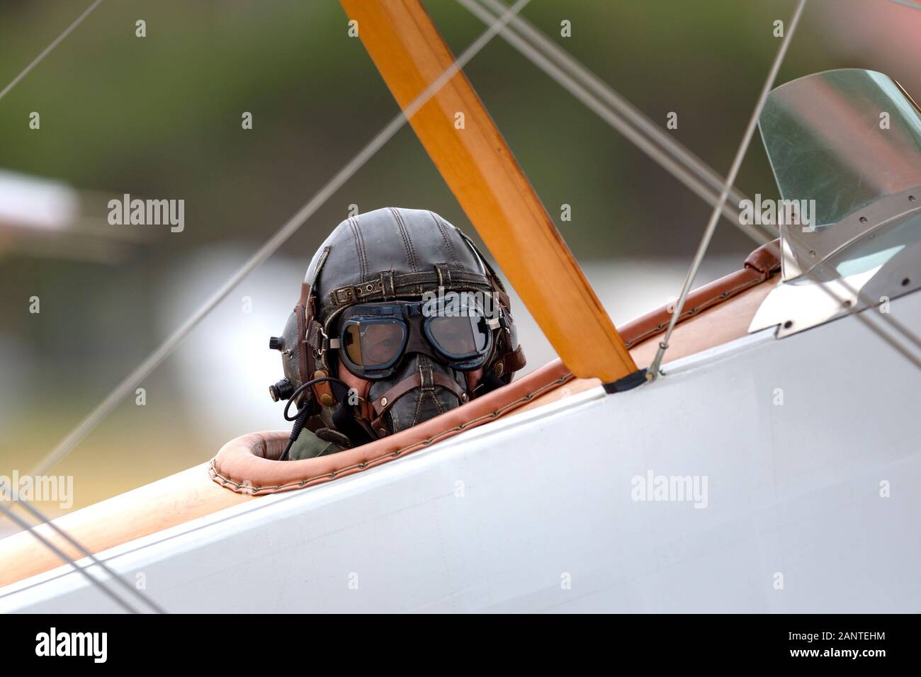 Pilot wearing vintage flying helmet and goggles int he cockpit of a vintage Sopwith Pup biplane operated by the RAAF Museum. Stock Photo