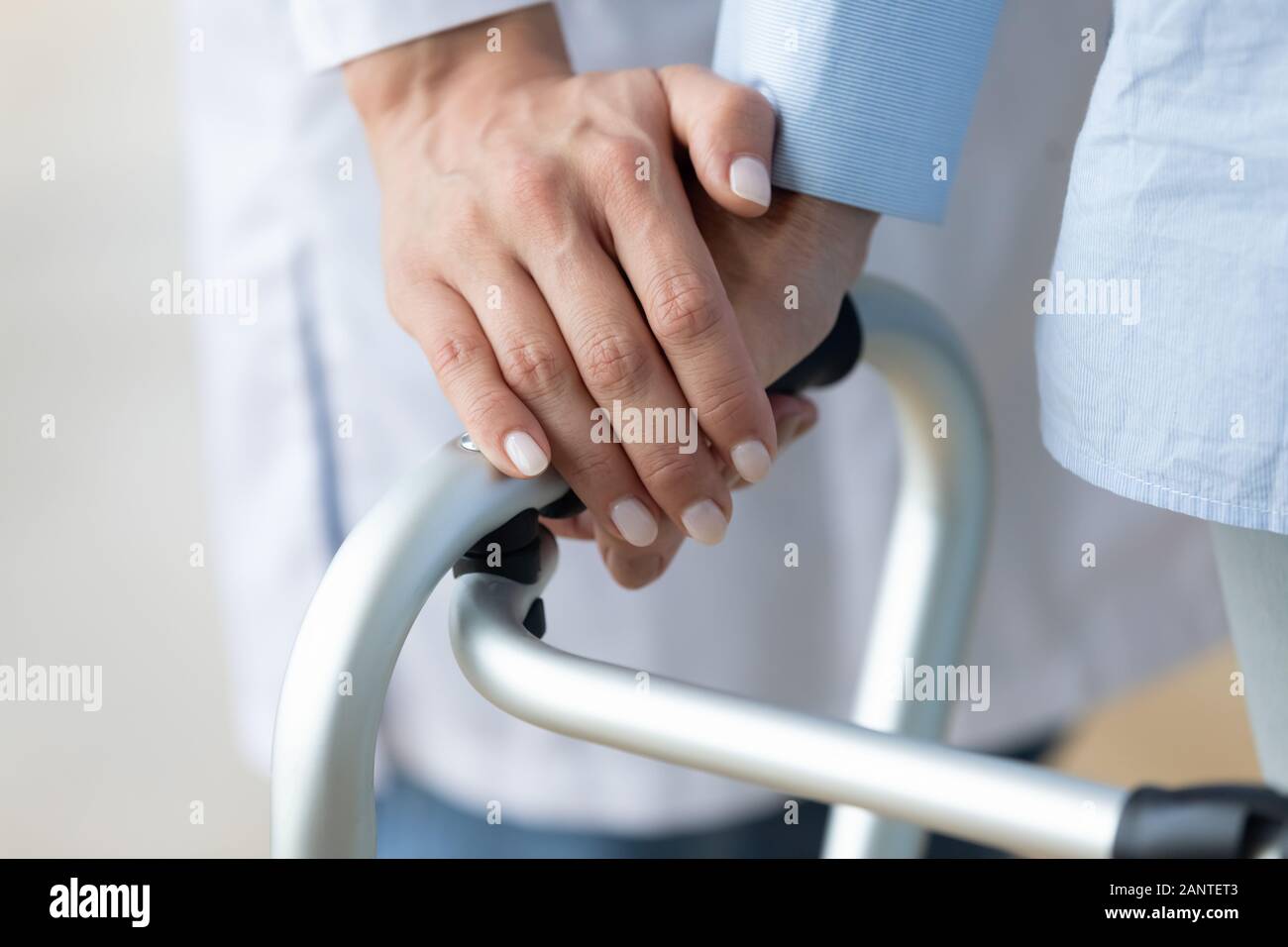 Close up caregiver holding older woman hand on walker Stock Photo