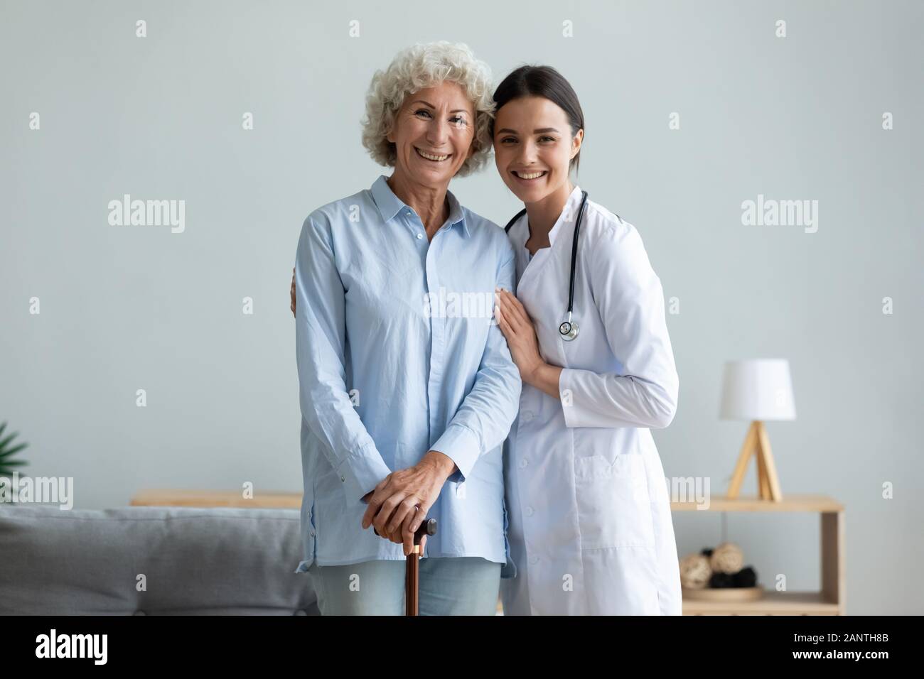 Portrait smiling caregiver and older woman with walking cane Stock Photo