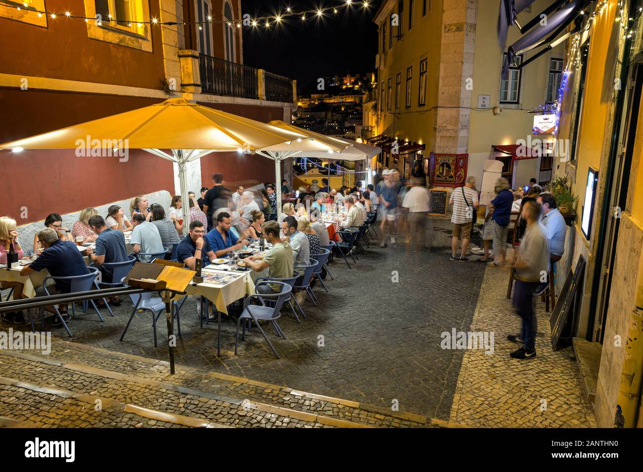 People dining al fresco at Calcada do Duque, cobblestoned pedestrian street that connects Bairro Alto and Rossio in Lisbon, Portugal, in the evening. Stock Photo