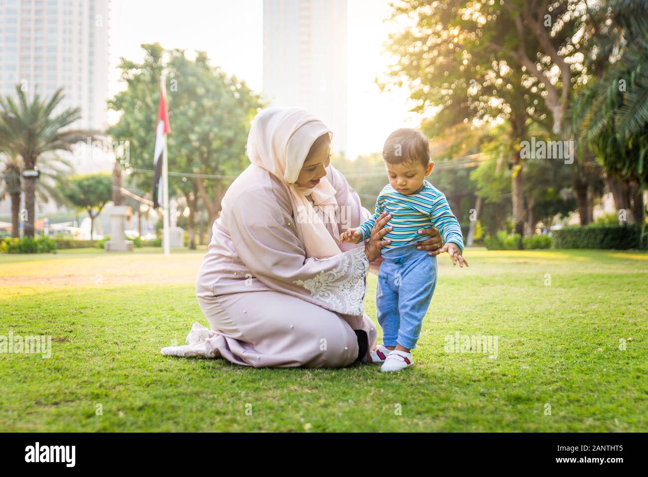 Middle eastern family with traditional dress having fun outdoors - Modern  islamic mom and son in Dubai Stock Photo - Alamy