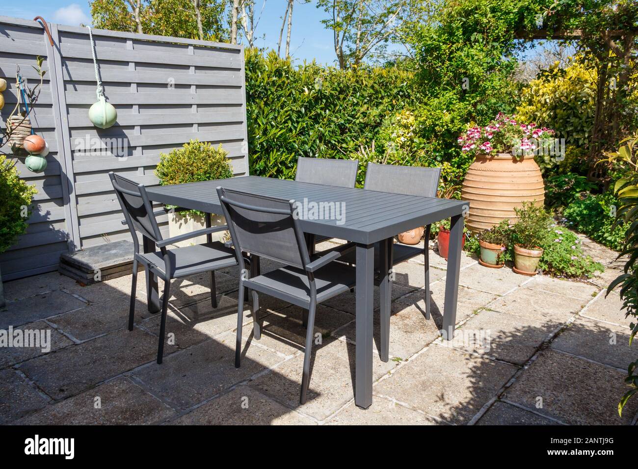 Flowered terrace with gray garden furniture during spring Stock Photo