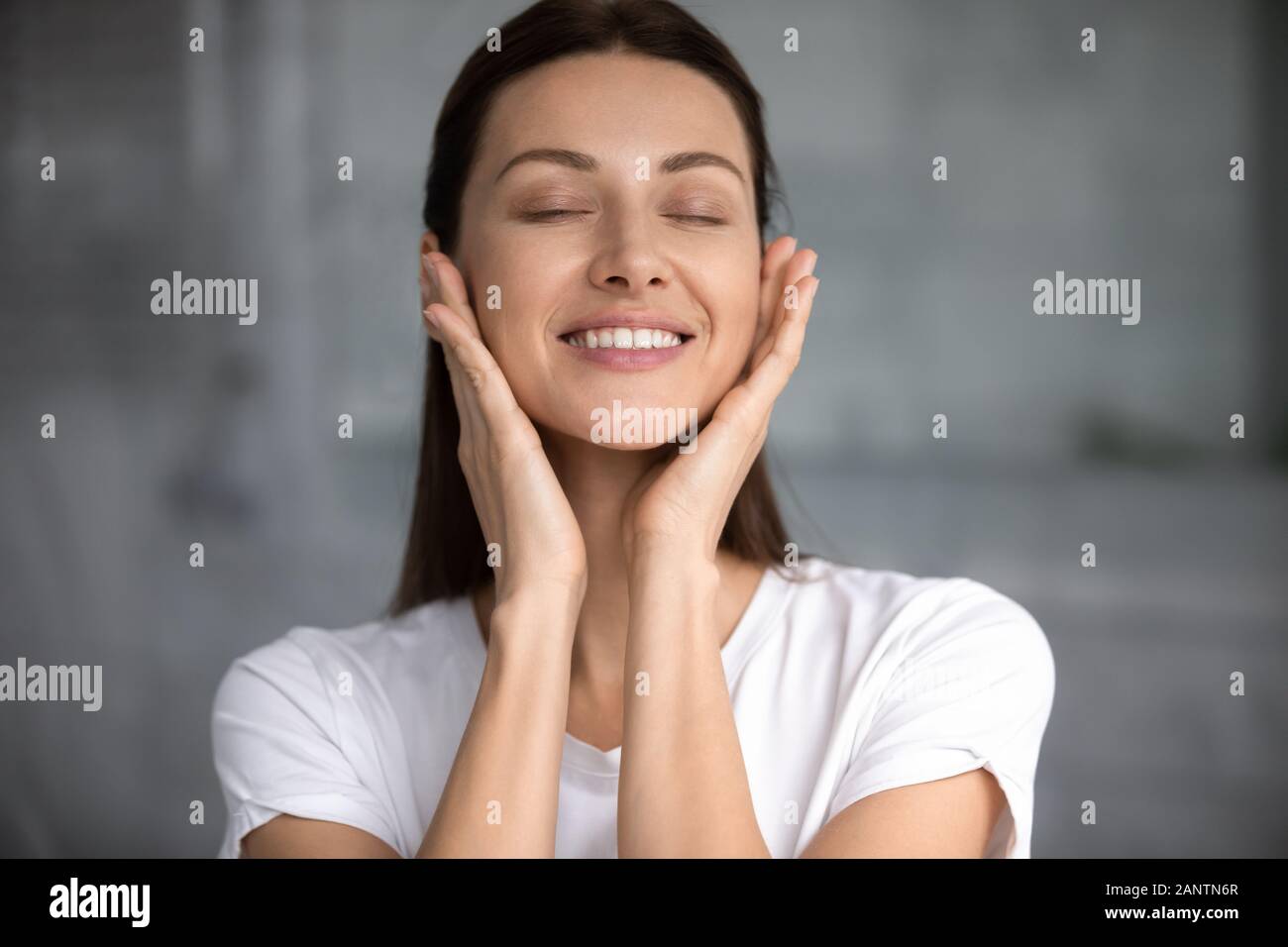 Head shot satisfied smiling woman with perfect skin touching face Stock Photo