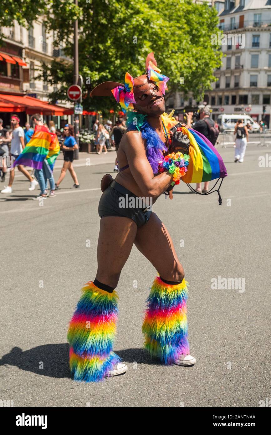 June 29 2019, Paris, France. Gay Pride Parade Day. Stripped smiling black extravagant young man with rainbow colored boots. Camera look. Stock Photo