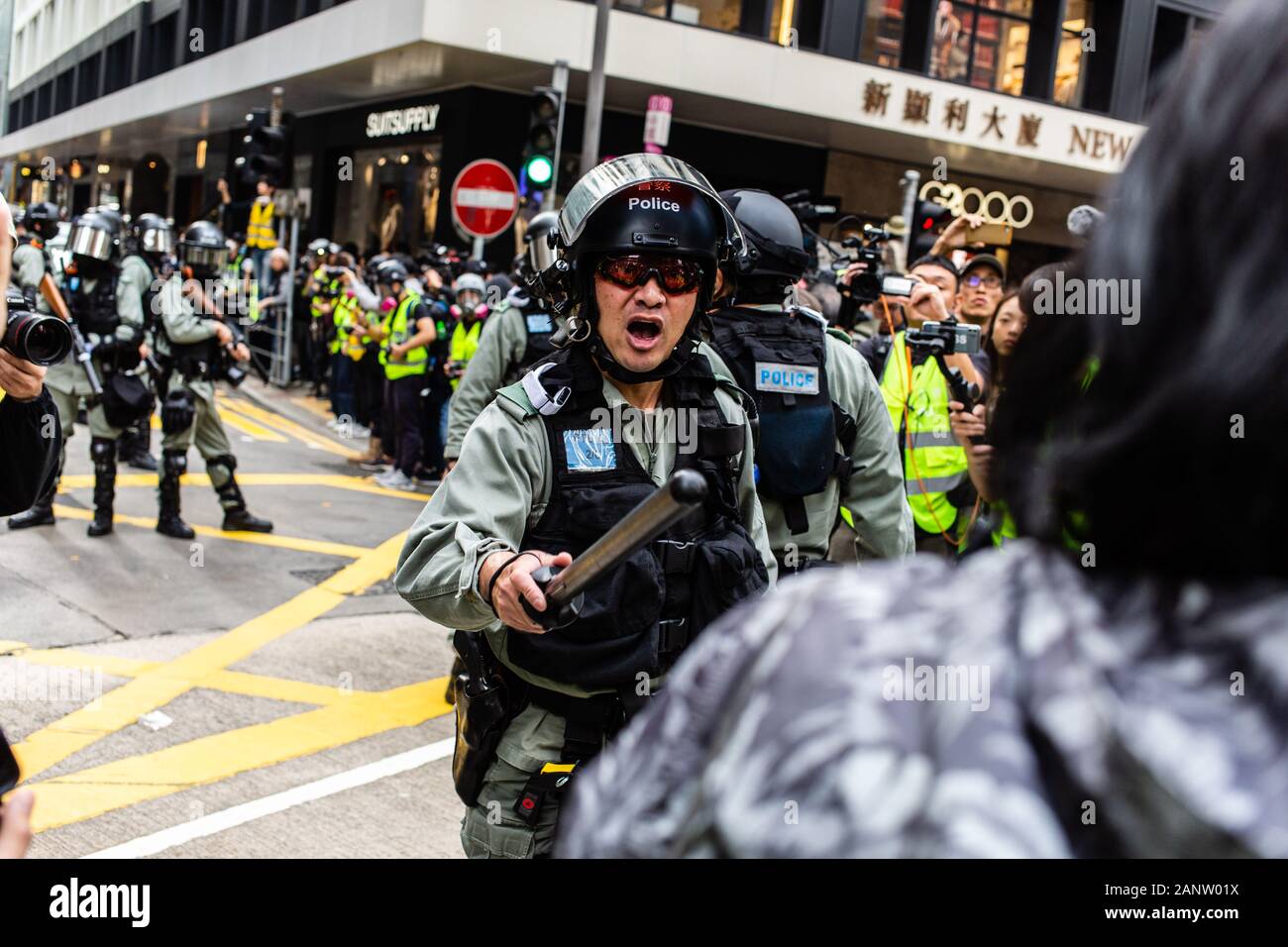 A riot police officer confronts a woman during the rally.Entering the 8th month of civil unrest, protesters gathered at an anti-communist rally, protesting against the Chinese Communist Party. Demonstrators listened to speeches, waved flags, and chanted slogans. Later, police in riot gear appeared and fired tear gas, arresting several protesters. Stock Photo