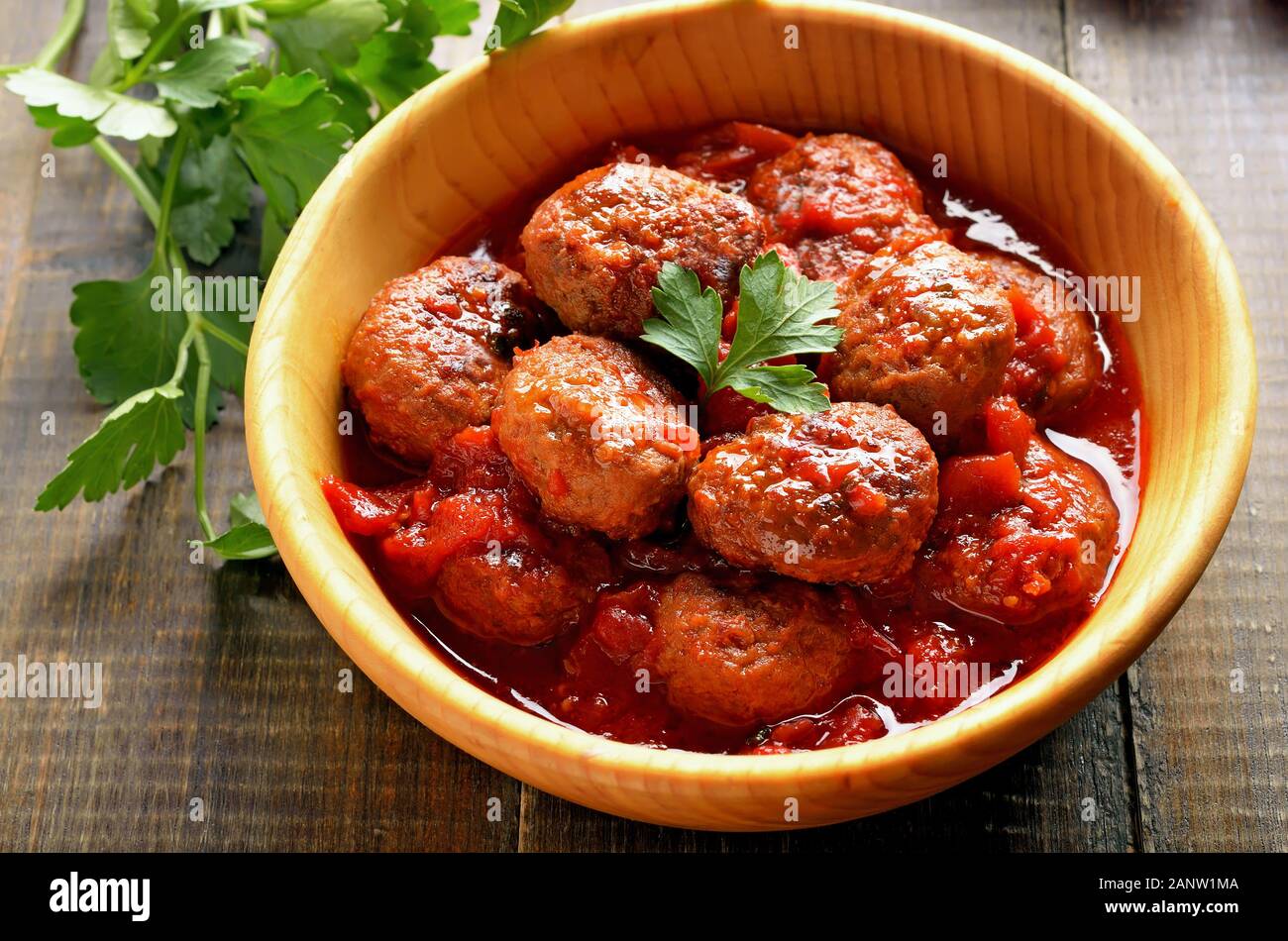 Fried meatballs in tomato sauce in wooden bowl. Close up view Stock