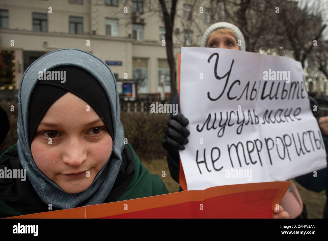 Moscow, Russia. 19th of January, 2020 Muslim woman holds banner reading 'Listen! Muslims are not terrorists' in a march in memory of lawyer Stanislav Markelov and journalist Anastasia Baburova in Tverskoy Boulevard in central Moscow, Russia Stock Photo