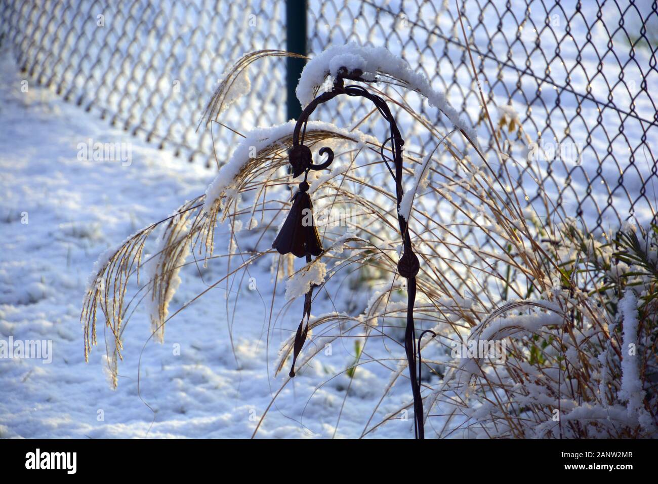 Snow Covered A Metal Winter Garden Decoration In Front Of Chain