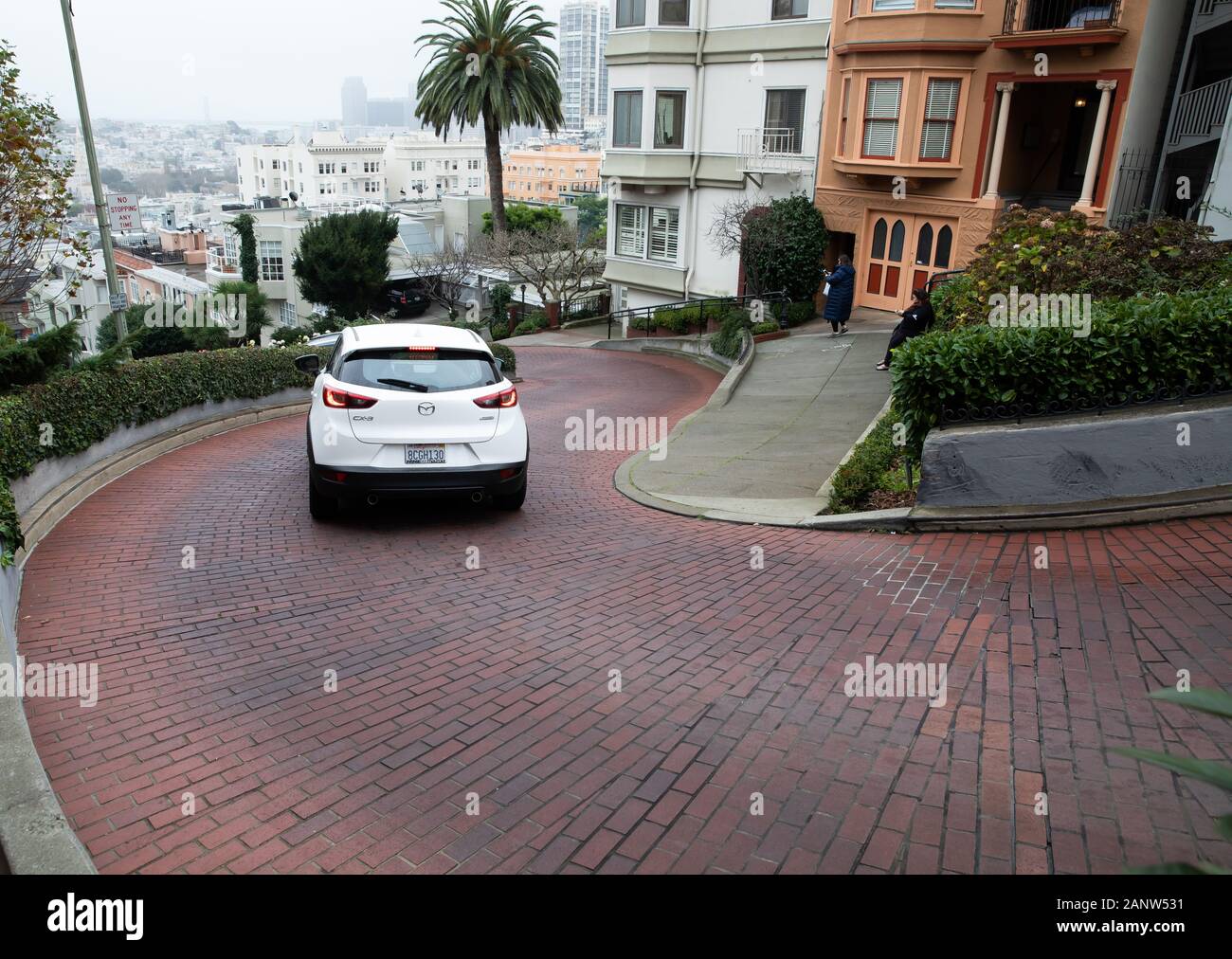 Cars drive slowly down Lombard Street, known as the crookedest street
