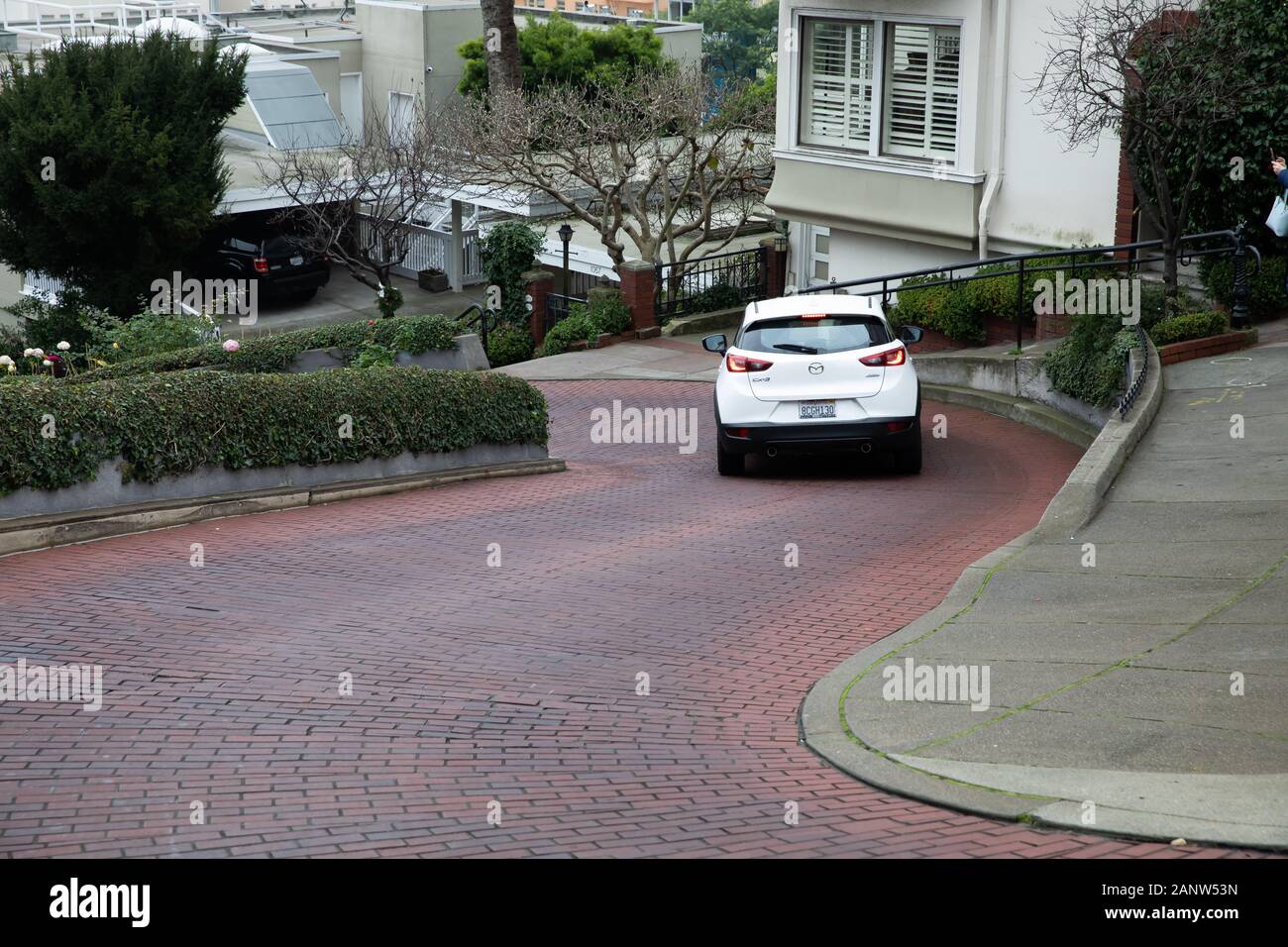 Cars drive slowly down Lombard Street, known as the crookedest street