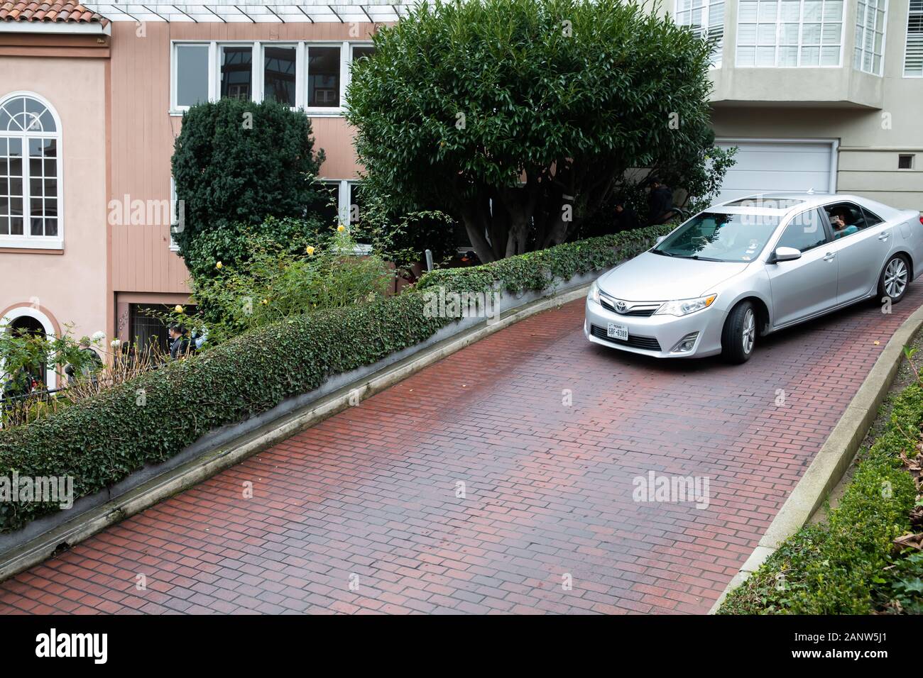 Cars drive slowly down Lombard Street, known as the crookedest street