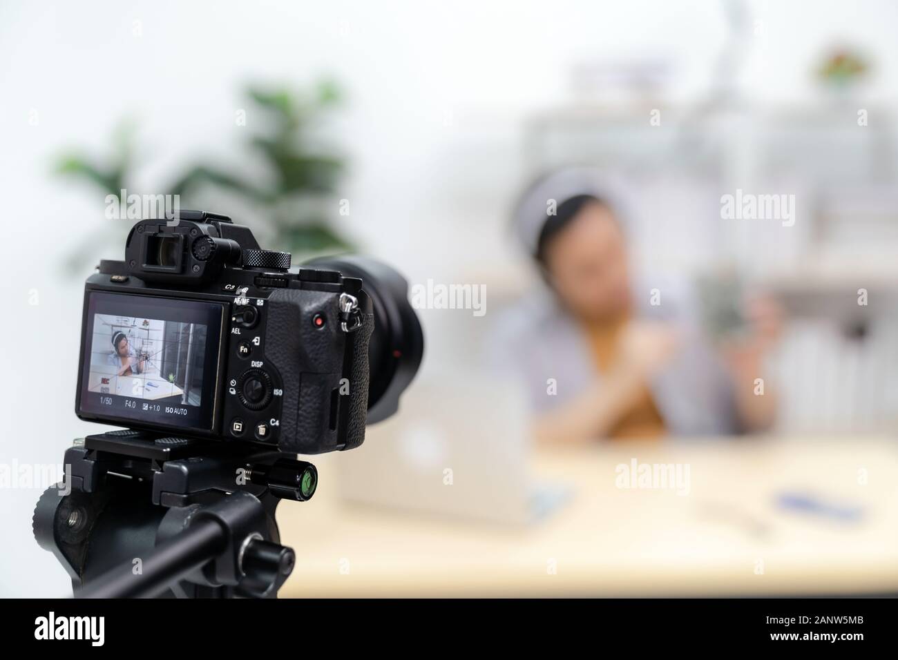 Young asian male IT vlogger and blogger live about Technology upgrand on laptop harddisk using digital camera to recording live vlog video. Online inf Stock Photo