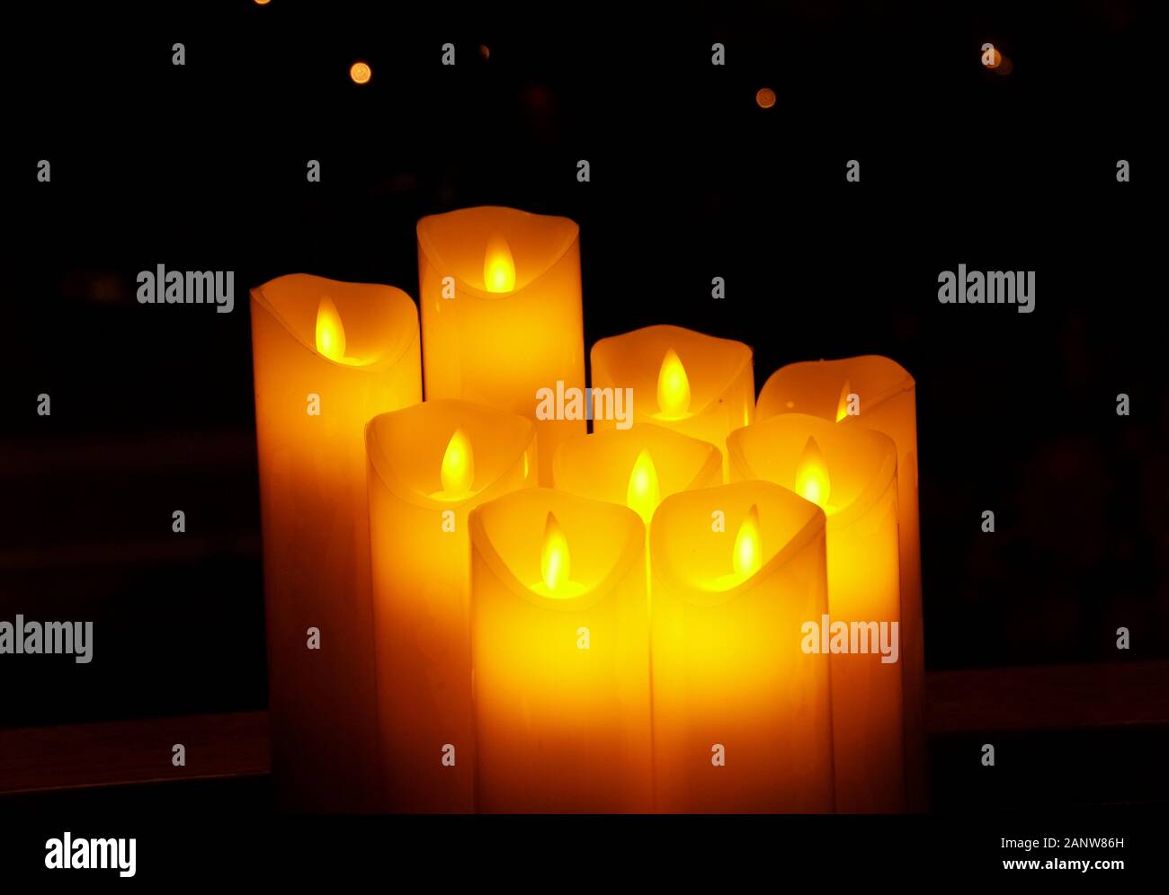 A bunch of yellow candles with flames in a dark setting Stock Photo Alamy