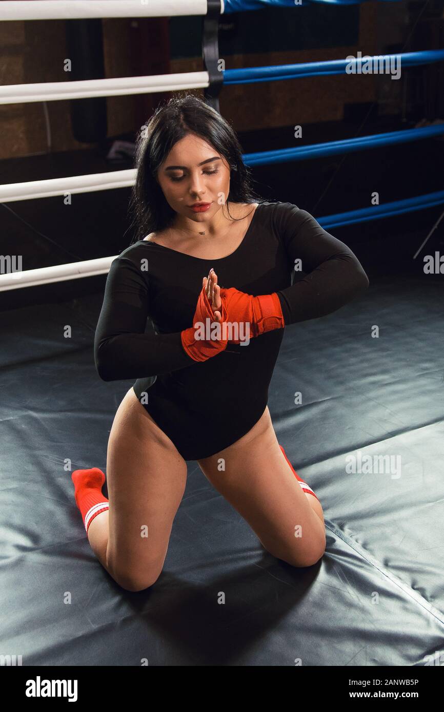 Boxer woman hands with red boxing wraps in the boxing ring. Closeup Hands of Female Fighter Wearing Boxing Bandages Preparation. The concept of female Stock Photo