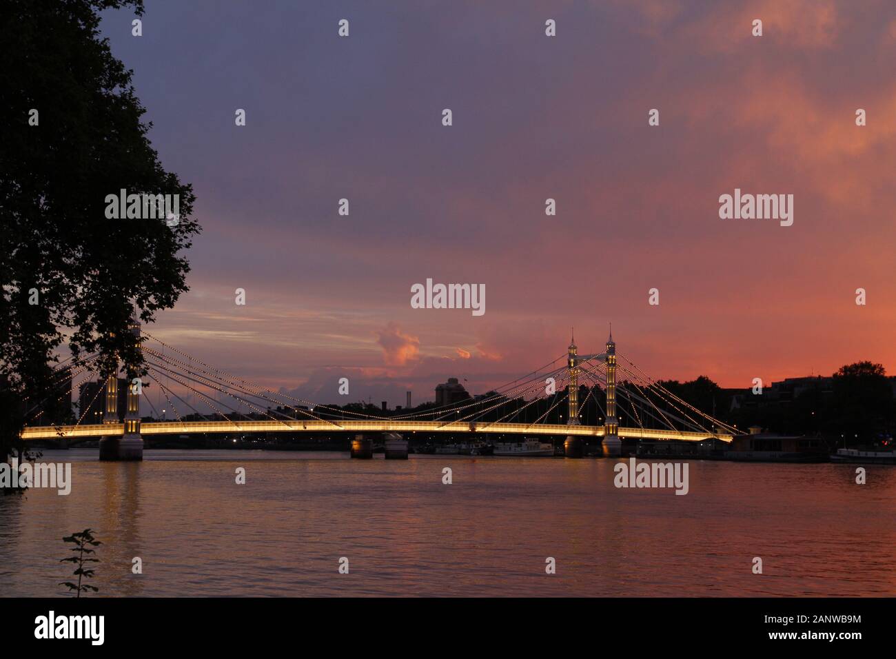 Albert Bridge, London,UK. View of Albert Bridge in the evening sunset with lights on the bridge being on. Stock Photo