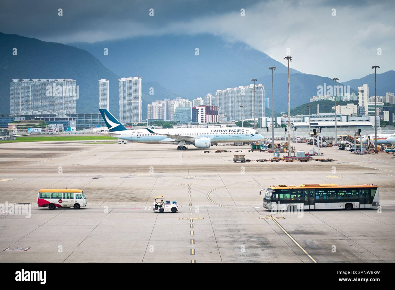 Hong Kong: View at the aircraft parking area at Hong Kong International Airport with skyscrapers and mountains in the background Stock Photo