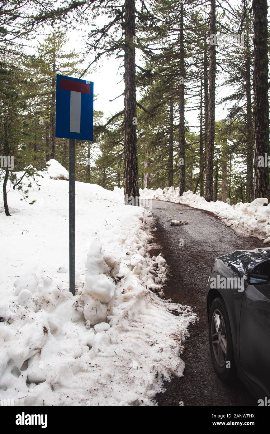 Car stopped on an impassable mountain road covered in snow during winter. Stock Photo