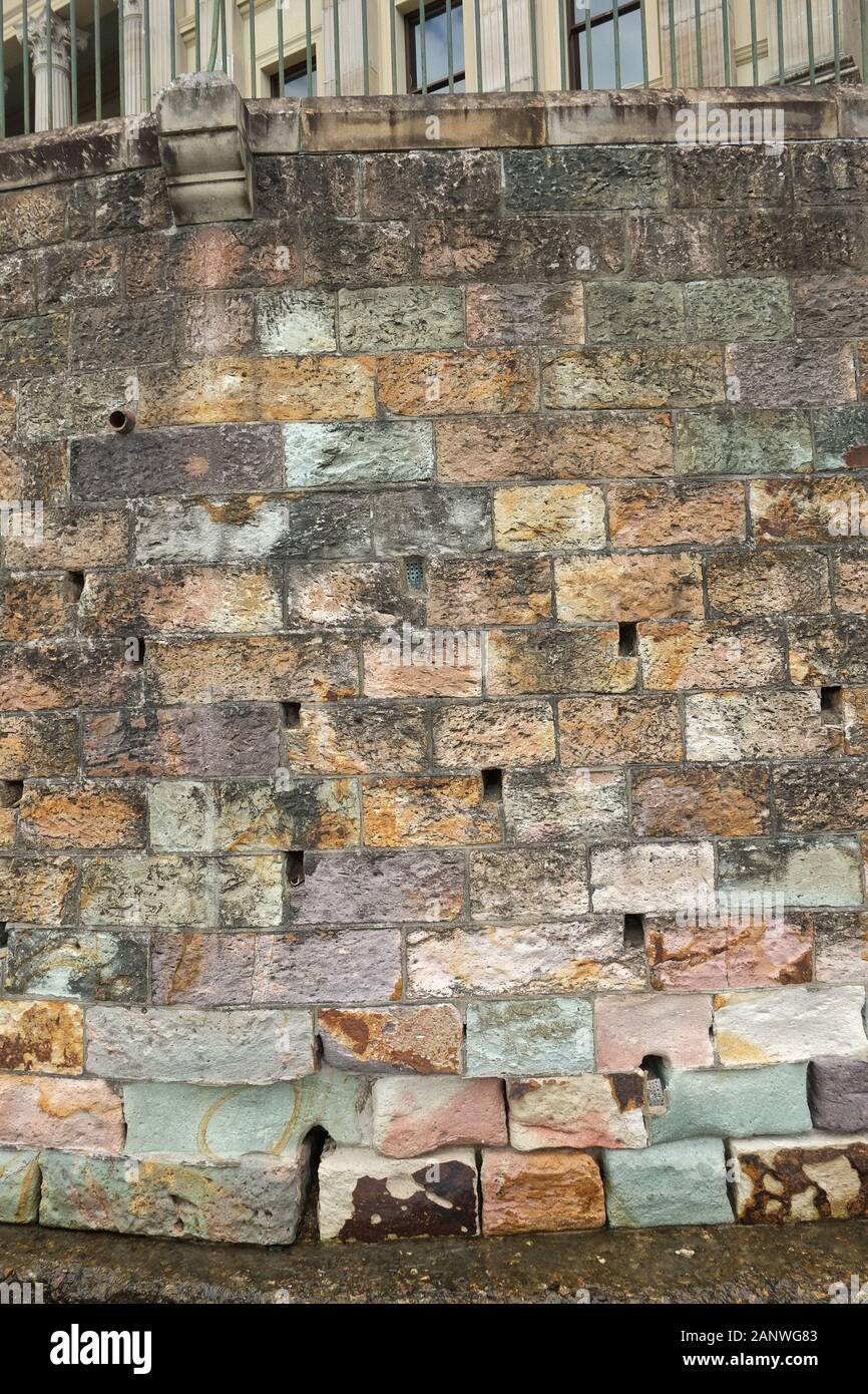 Multi coloured hewn blocks of stone of the retaining wall below