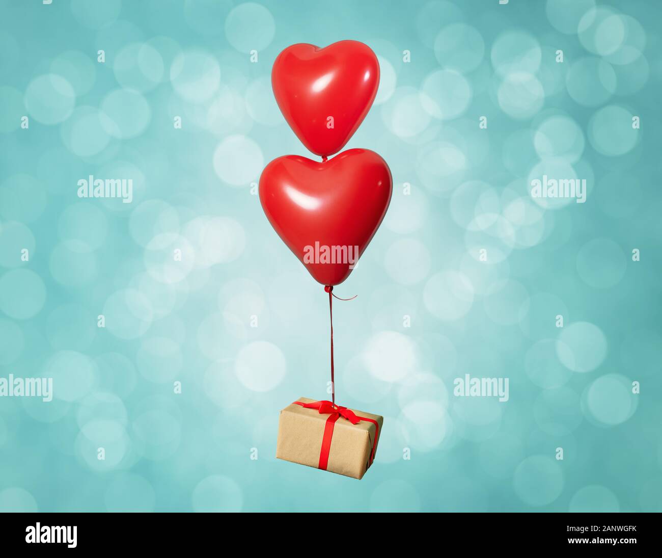 Two heart shaped red air baloon carrying a gift box front of a shiny ...