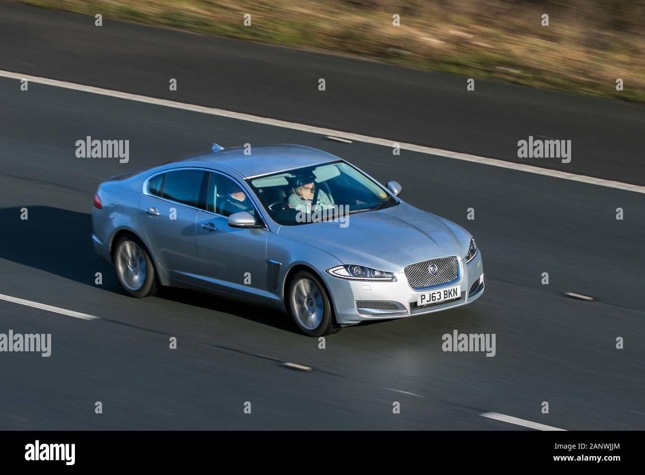 Jaguar Xf Premium Luxury D Auto Silver Diesel driving on the M6 motorway near Preston in Lancashire, UK Stock Photo