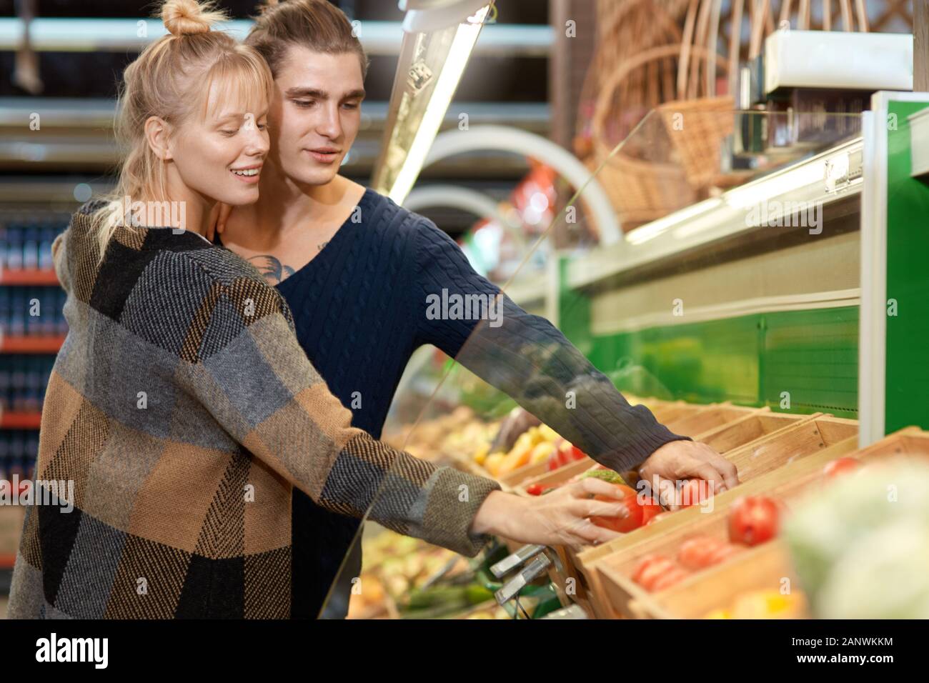 Young adult couple choosing vegetables in grocery store Stock Photo - Alamy