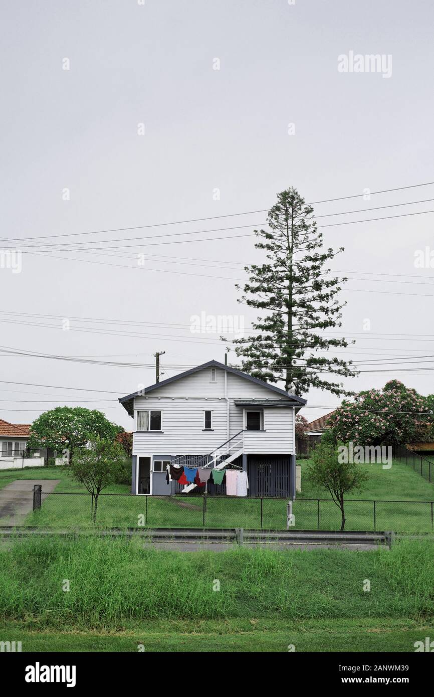 A Post War, Housing Commission House on a large grassy block with a concrete slab driveway in the Brisbane suburb of Seven Hills Stock Photo